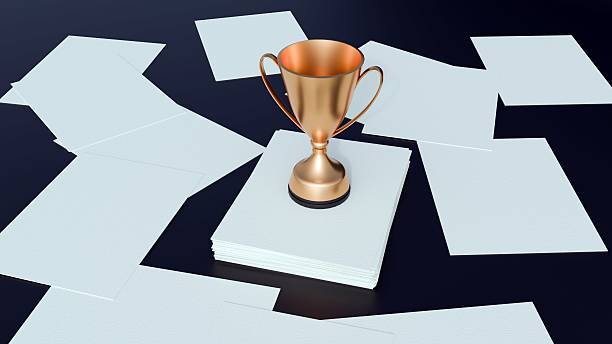 A classic golden trophy standing on a neat stack of white papers