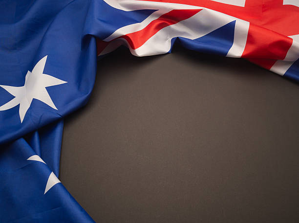 istock Draped Australian flag on a dark textured surface, leaving space for message or design. 2211572325