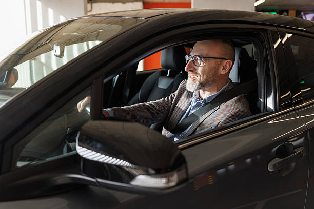 istock Smiling professional man driving a car in a modern setting 2211572606