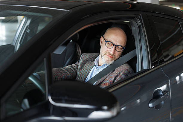 istock Businessman driving a car while looking thoughtful and focused 2211572626