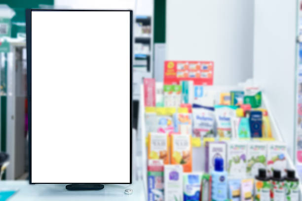 istock Pharmacy store. Blank empty white display panel advertising sign against blurred shelves in medical shop. Drugstore sales pills, vaccines and health care products 2211574802