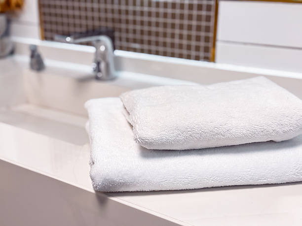 istock Soft white towels neatly stacked on a clean countertop in a modern bathroom setting 2211575815