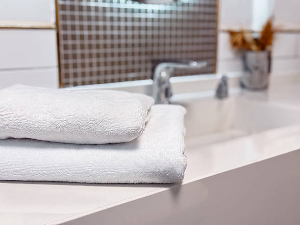 istock Soft white towels neatly stacked on a clean countertop in a modern bathroom setting 2211575852