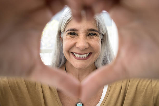 istock Cheerful blonde grey haired elderly Latin woman looking at camera 2211576043
