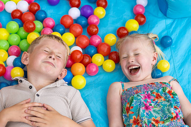 Young boy playing in a ball pool in kid's playroom.