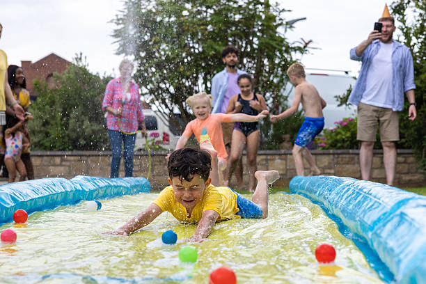 istock Splashing Down the Slip and Slide 2211576378