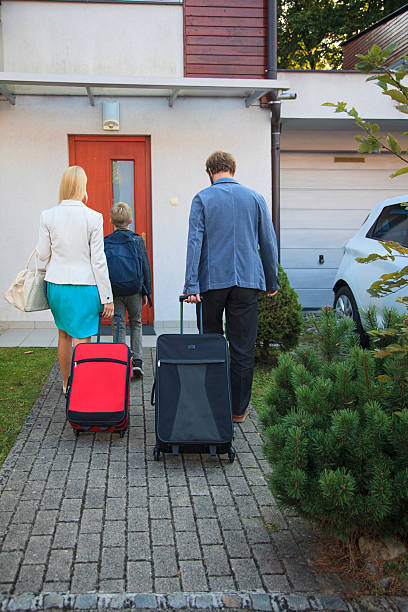 istock Family Returning Home from Vacation with Luggage 2211576503