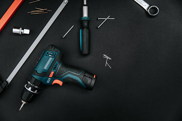 istock Hand tools set on dark board. Cordless drill, screwdriver, wrench, cutter. Flat lay, top view 2211577169