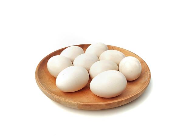istock Fresh chicken eggs on wooden plate isolated on white background 2211578331