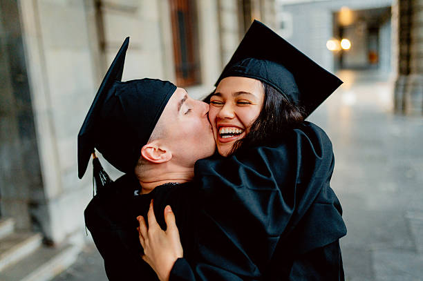 istock Happy students kissing and celebrating graduation day 2211578431