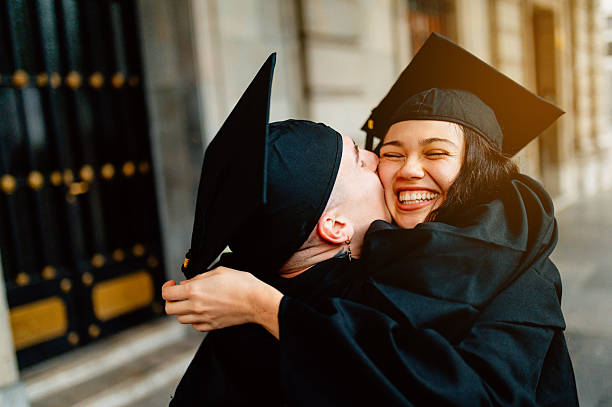 istock Two happy students hugging and celebrating graduation day 2211578489