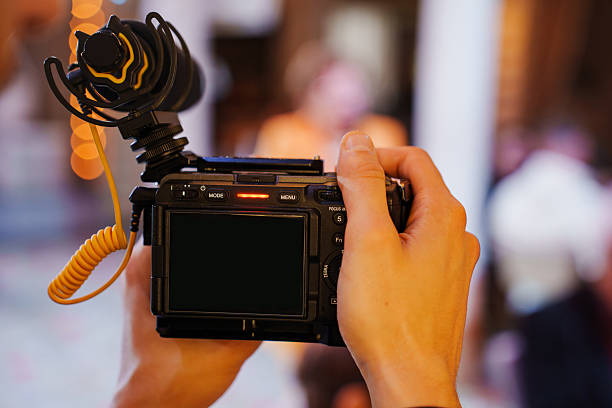 istock Men's hands with a professional camera are filming a performance at a banquet. 2211582756
