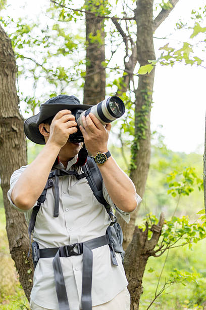 istock Landscape photographer working outdoors holding camera 2211583072
