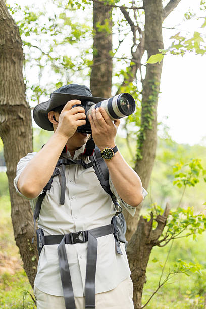 istock Landscape photographer working outdoors holding camera 2211583080