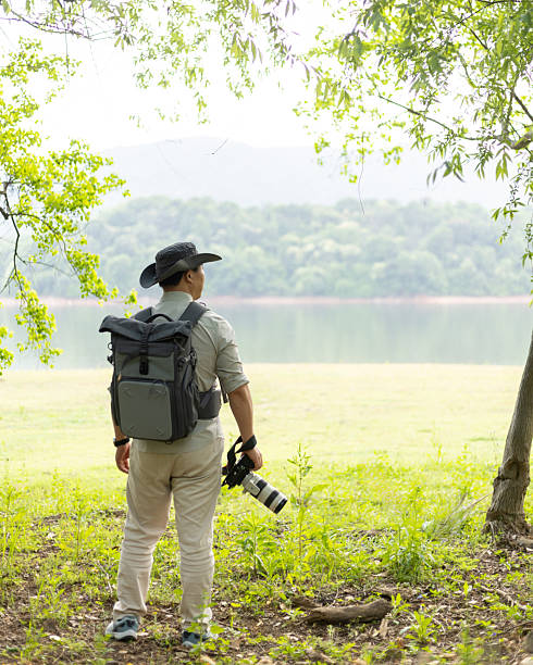 istock Landscape photographer working outdoors holding camera 2211583121