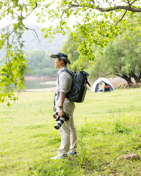 istock Landscape photographer working outdoors holding camera 2211583132