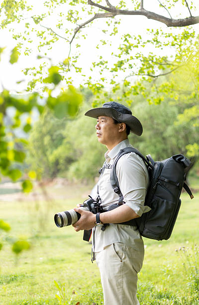 istock Landscape photographer working outdoors holding camera 2211583149