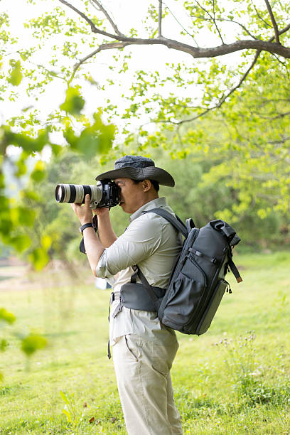 istock Landscape photographer working outdoors holding camera 2211583167