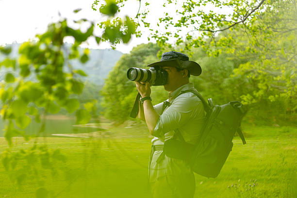 istock Landscape photographer working outdoors holding camera 2211583186