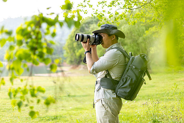 istock Landscape photographer working outdoors holding camera 2211583197