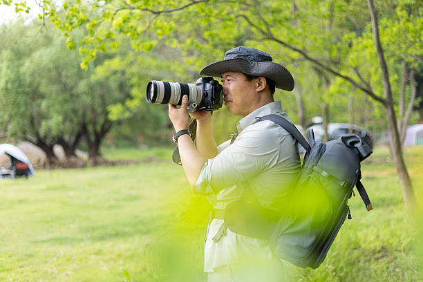 istock Landscape photographer working outdoors holding camera 2211583206