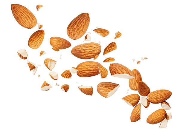 istock Almond nuts  levitating in air on white background. Isolated Falling crushed almonds nuts. Almonds is torn to pieces explosion with crumbs. Almond package design elements 2211585147