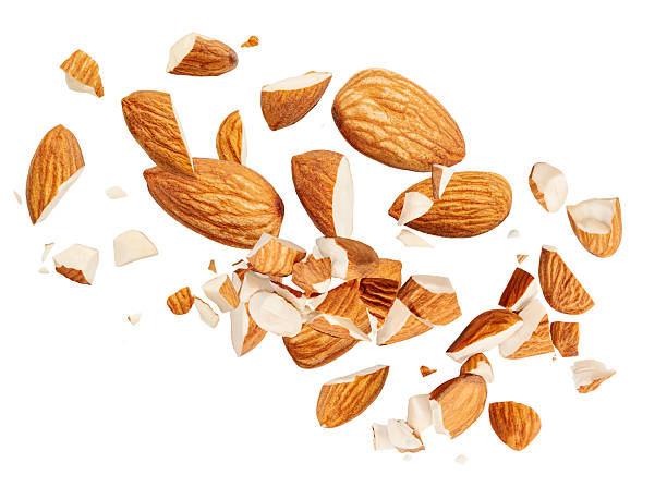 istock Almond nuts  levitating in air on white background. Isolated Falling crushed almonds nuts. Almonds is torn to pieces explosion with crumbs. Almond package design elements 2211585212