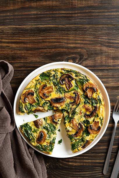 istock Delicious frittata with spinach and champignon mushrooms 2211585592