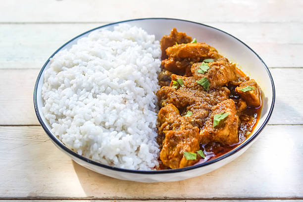 istock chicken curry with rice in a plate, on a wooden table 2211586273