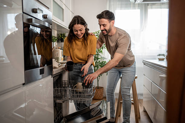 istock Happy couple unloading dishes from dishwasher in modern kitchen 2211587214
