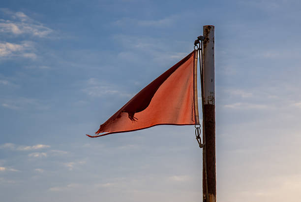 istock Red flag on a beach and blue sky, Spain 2211592138
