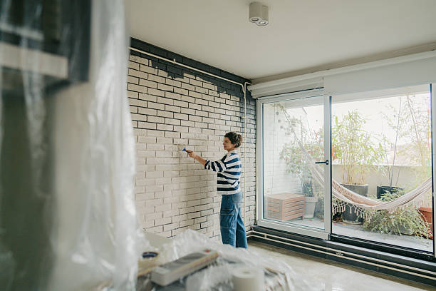 istock Young woman painting a wall 2211596367