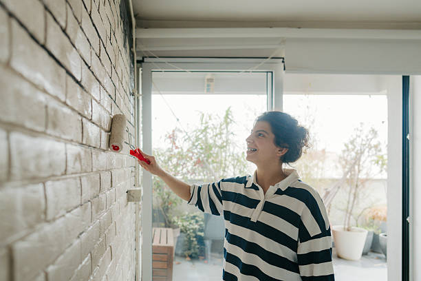 istock Young woman painting a wall 2211596379