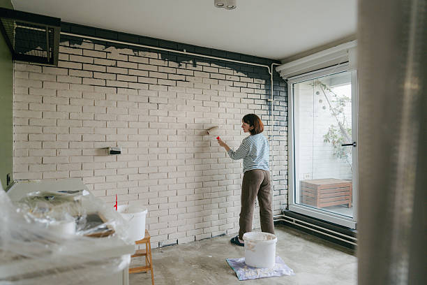 istock Young woman painting a wall 2211596396