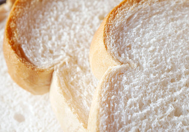 One loaf of slightly moldy white bread, on white plate, isolated on white background