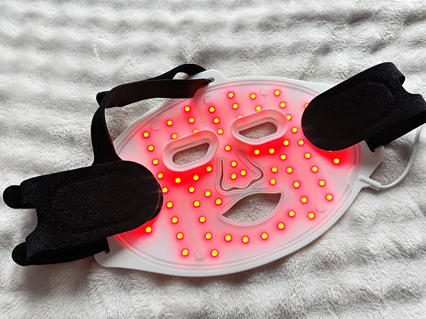 Led light therapy face mask on soft fabric, top view. Beauty treatment