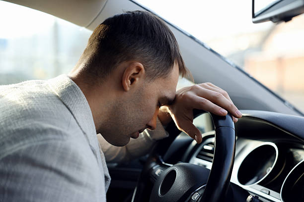istock Tired driver sleeping on steering wheel in car 2211599049