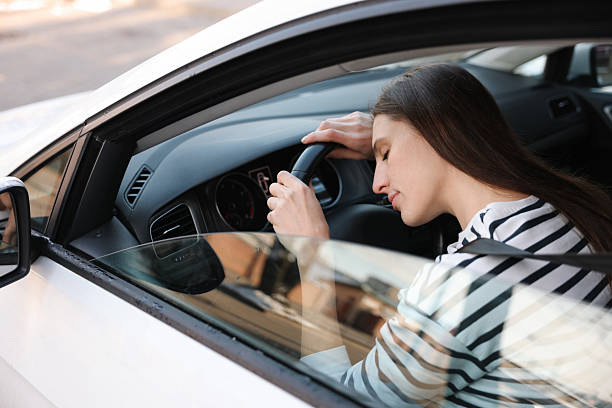 istock Tired driver sleeping on steering wheel in car, view from outside 2211599074
