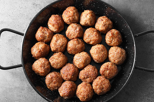 Tasty meatballs in baking dish on grey table, top view