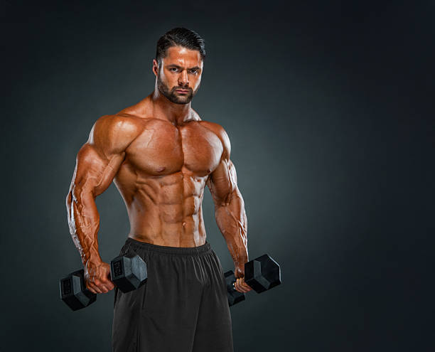 istock Muscular Man Posing, Holding Dumbbells 2211604988