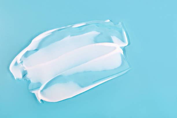 istock White cosmetic cream smear on blue background, showing rich texture and smooth consistency 2211608815