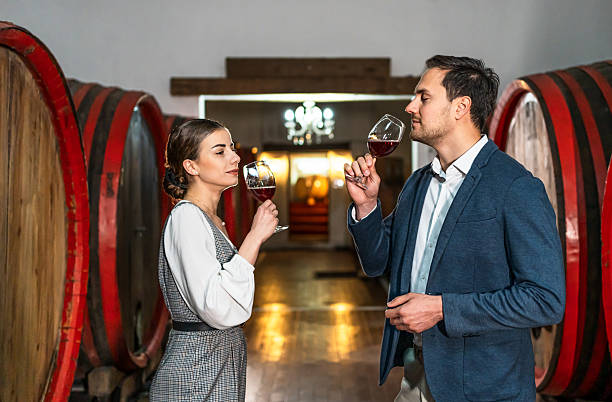 istock Winemakers smelling wine in cellar with wooden barrels 2211609189