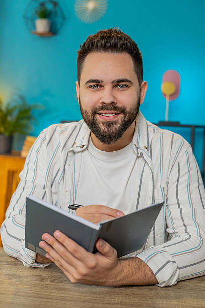 istock POV laptop view of freelancer man study with notebook making notes conference video call education 2211609568