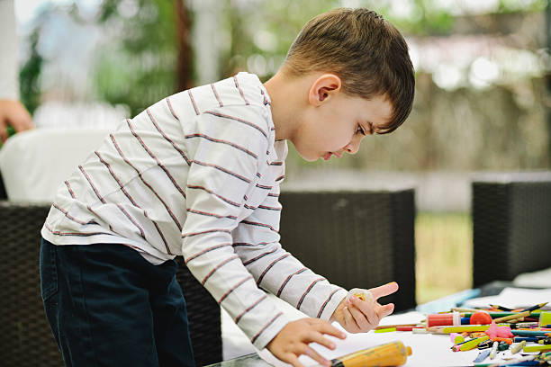 istock Focused Boy Looking for Perfect Colored Pencil For His Drawing 2211611353