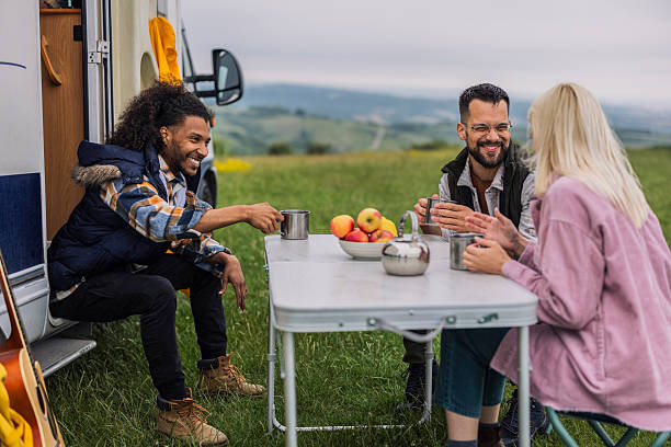 istock Friends enjoying hot drinks and conversation at camper van campsite 2211613310