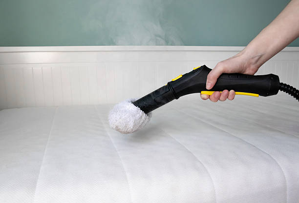istock Sanitizing and cleaning mattress using steam cleaning method at home to remove dust mites, bacteria, and allergens. 2211615279