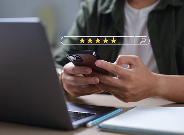 istock Businessman uses smartphone to provide five-star feedback for customer satisfaction survey, increasing company rating and improving service quality. 2211619044