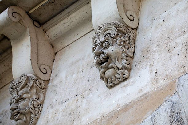 Two of the 381 mascarons on Pont Neuf - stone masks that decorate the bridge's sides. Pont Neuf is the oldest standing bridge across the river Seine in Paris, France.