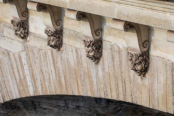 Some of the 381 mascarons on Pont Neuf - stone masks that decorate the bridge's sides. Pont Neuf is the oldest standing bridge across the river Seine in Paris, France.