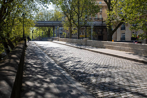 istock Cobblestone city street in dappled light with copy space 2211622702